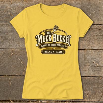 Yellow t-shirt with "The Muck Bucket School of Stall Cleaning Opens at 5 AM" text.