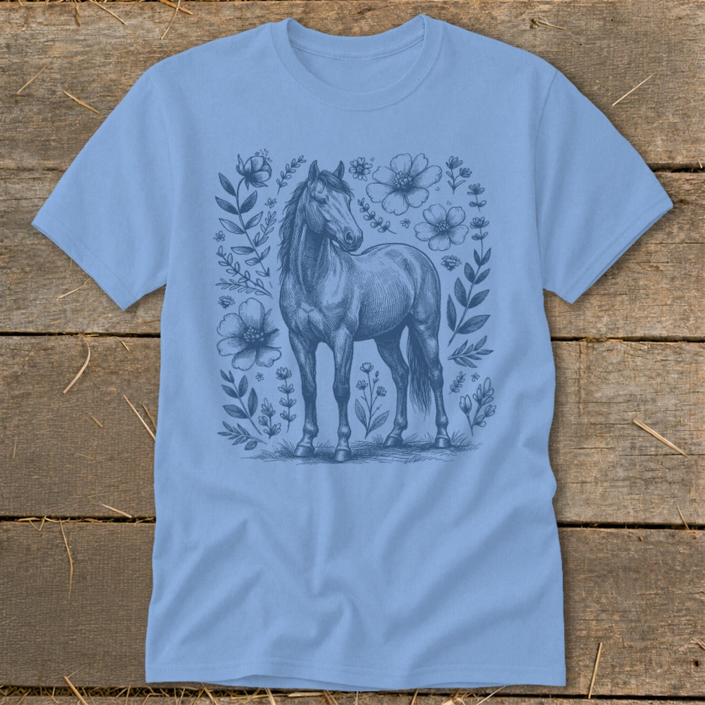 Light blue t-shirt with a blue sketch of a horse surrounded by flowers and leaves.