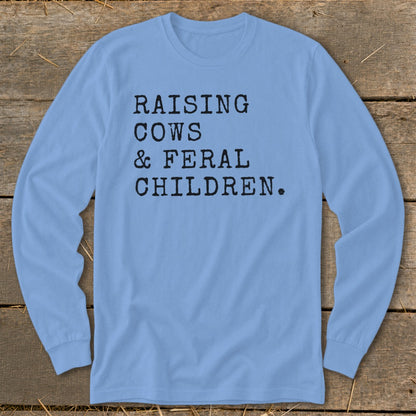 Light blue long sleeve shirt with black text: Raising Cows & Feral Children.