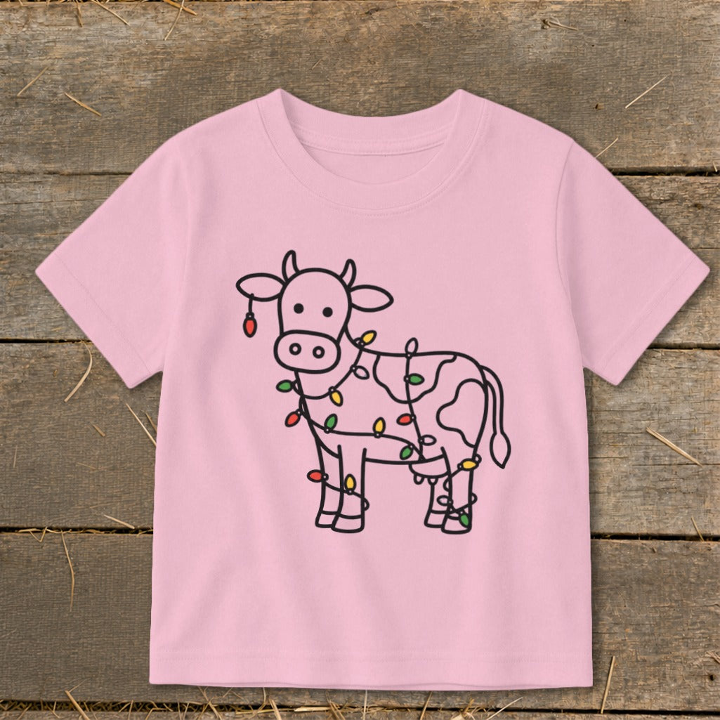 Pink t-shirt with a line drawing of a cow decorated with colorful Christmas lights.