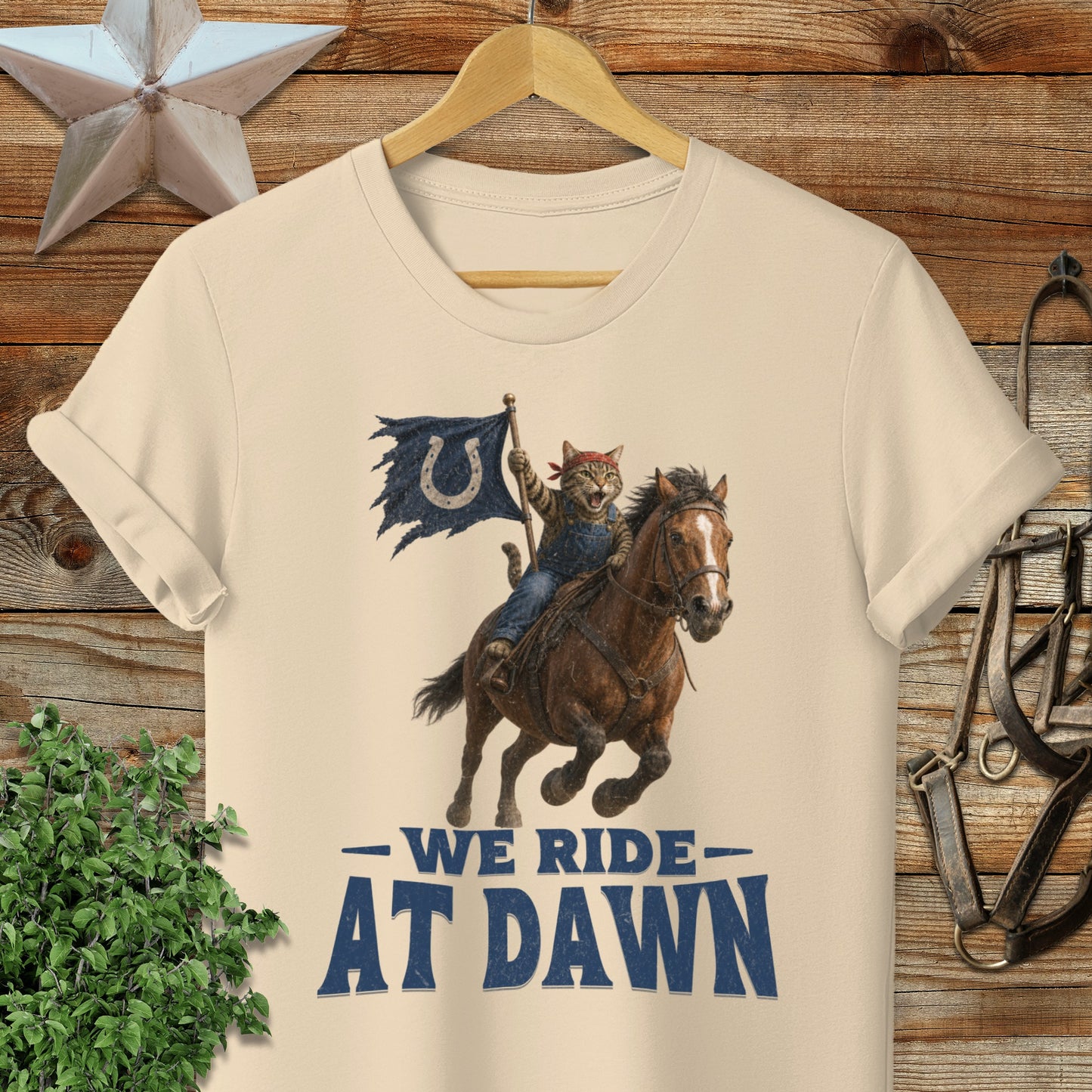 Cat cowboy on horseback with flag, text "WE RIDE AT DAWN".