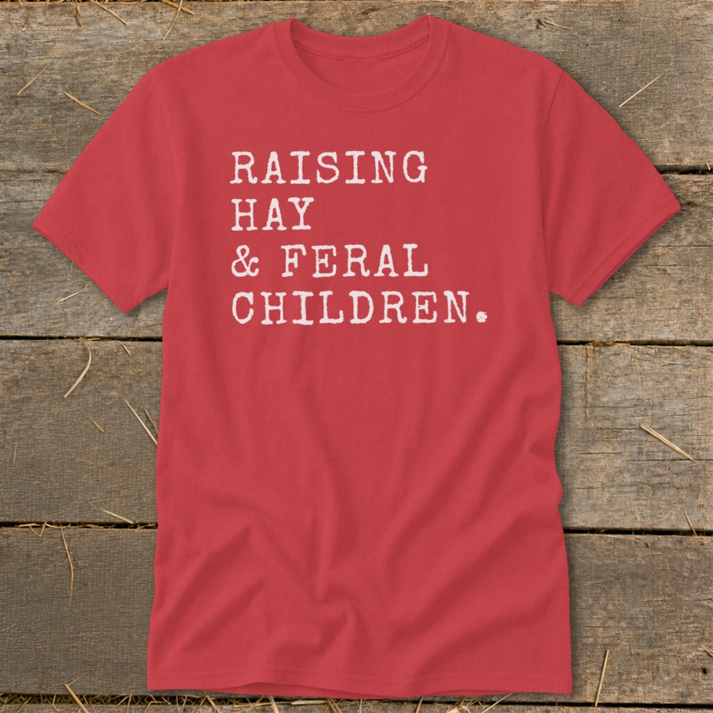 Red t-shirt with white text reading "RAISING HAY & FERAL CHILDREN."