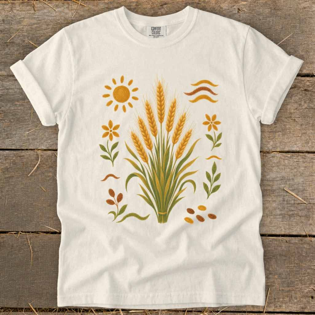 White t-shirt with embroidered wheat stalks, sun, flowers, and leaves design.