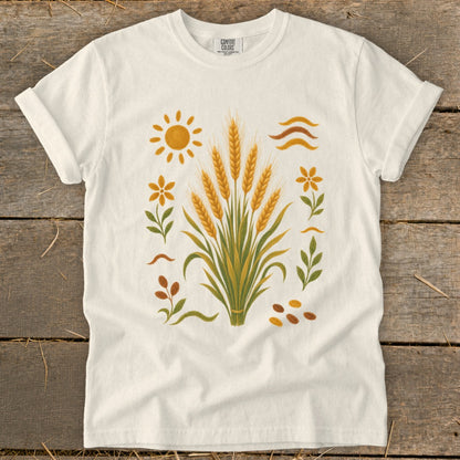 White t-shirt with embroidered wheat stalks, sun, flowers, and leaves design.