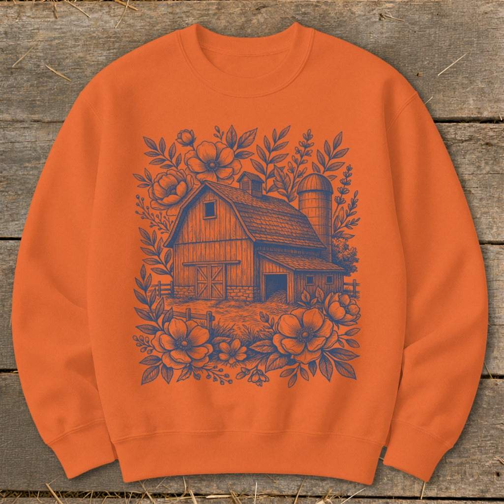 Orange sweatshirt with a navy blue barn and floral illustration.