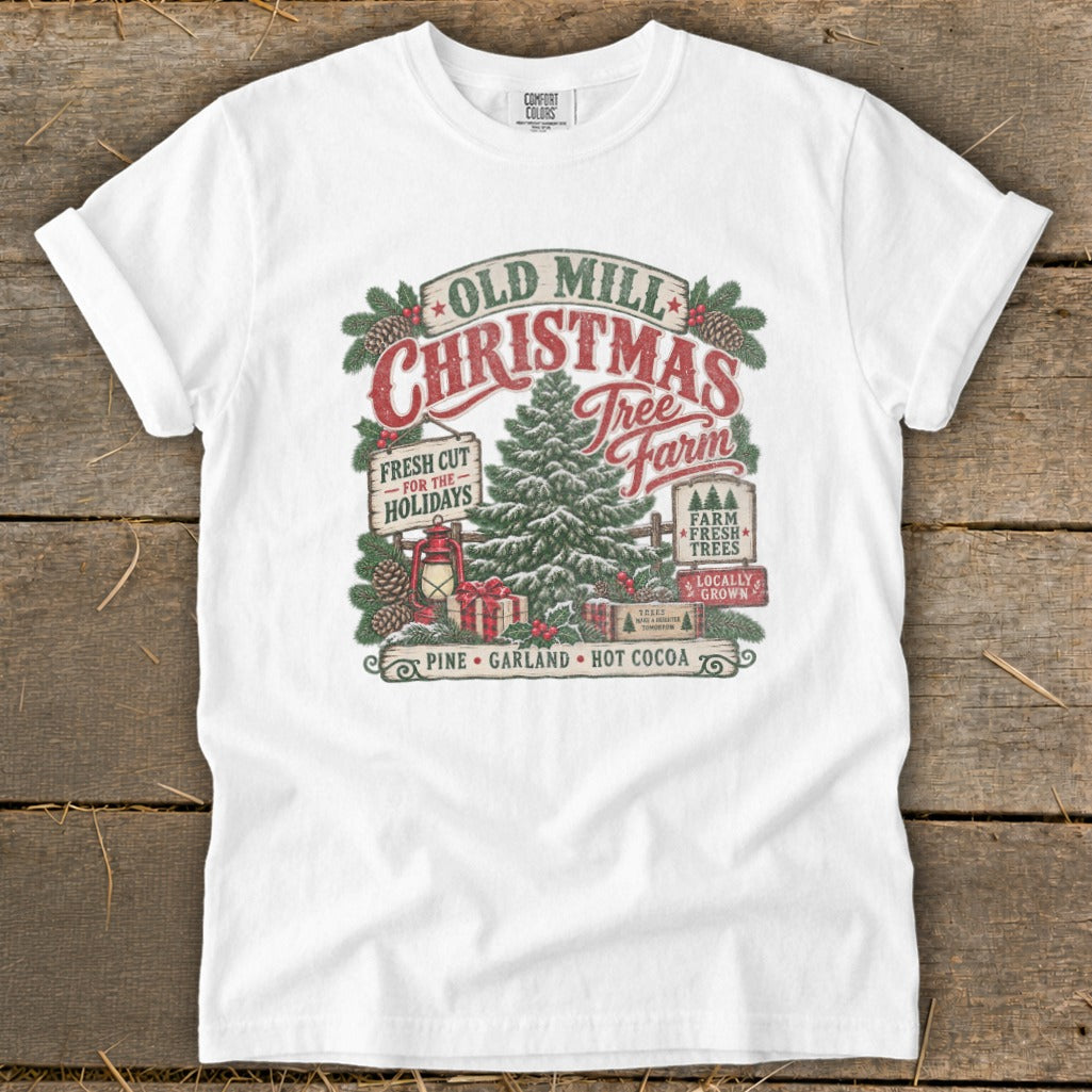 White t-shirt with Old Mill Christmas Tree Farm graphic featuring a tree, gifts, and holiday text.