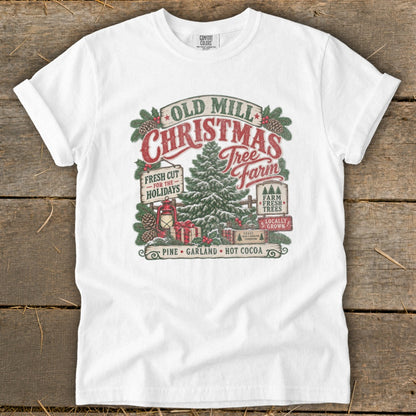 White t-shirt with Old Mill Christmas Tree Farm graphic featuring a tree, gifts, and holiday text.