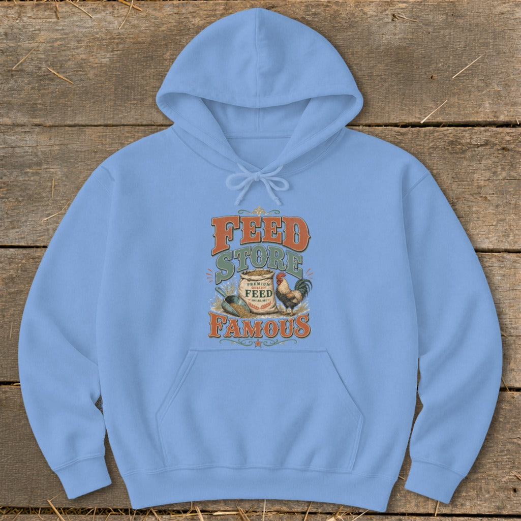 Light blue hoodie with "Feed Store Famous" graphic featuring a bag of feed, chicken, and scoop.