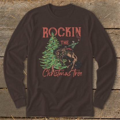 Brown long-sleeve shirt with "Rockin The Christmas Tree" graphic featuring a rodeo rider and a Christmas tree.