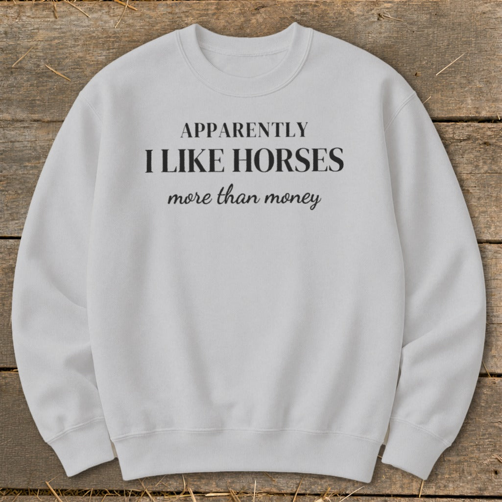 White sweatshirt with text "APPARENTLY I LIKE HORSES more than money."