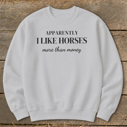 White sweatshirt with text "APPARENTLY I LIKE HORSES more than money."