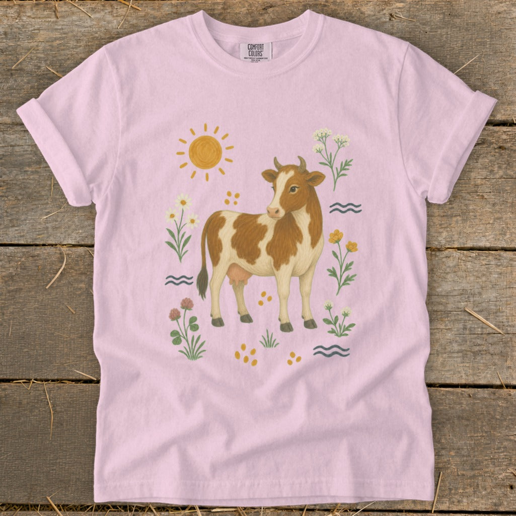 Pink t-shirt with a brown and white cow and floral accents.
