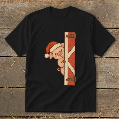 Black t-shirt with a cartoon pig wearing a Santa hat peeking from behind a red barn door.