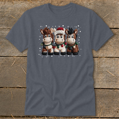 Three cartoon horses wearing Santa hats and Christmas lights stand together.