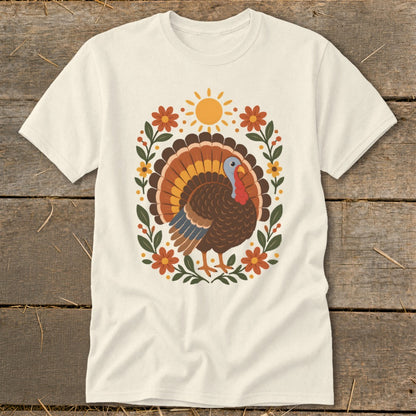 Cream t-shirt with a colorful turkey illustration surrounded by floral and sun graphics.