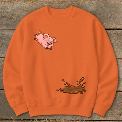 Orange sweatshirt with a cartoon pig jumping through a mud puddle.