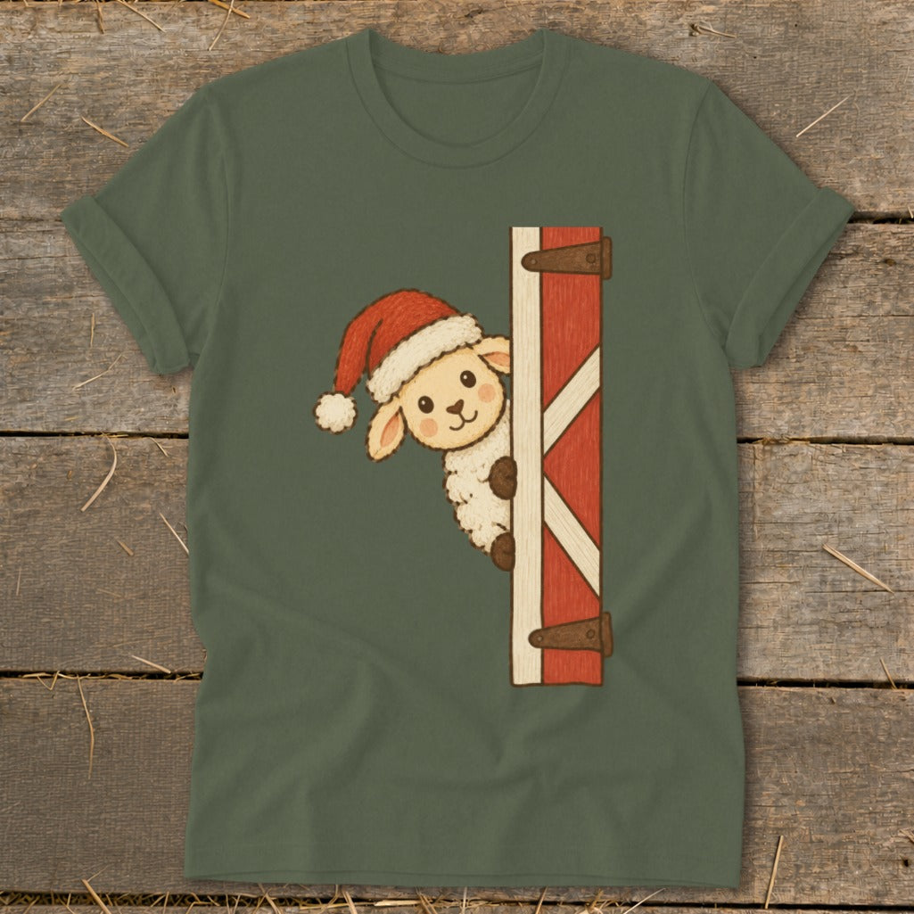 Sheep in Santa hat peeking from behind barn door on olive green t-shirt.