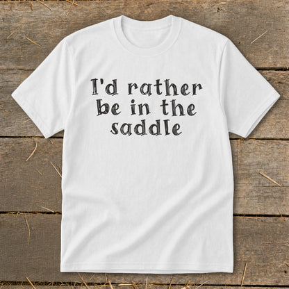 White t-shirt with "I'd rather be in the saddle" text in black serif font.