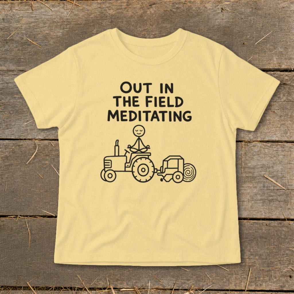 Yellow t-shirt with black text and illustration of stick figure meditating on a tractor.