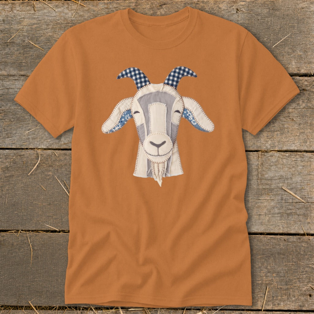 Orange t-shirt with a stitched applique of a goat's face featuring blue plaid horns.