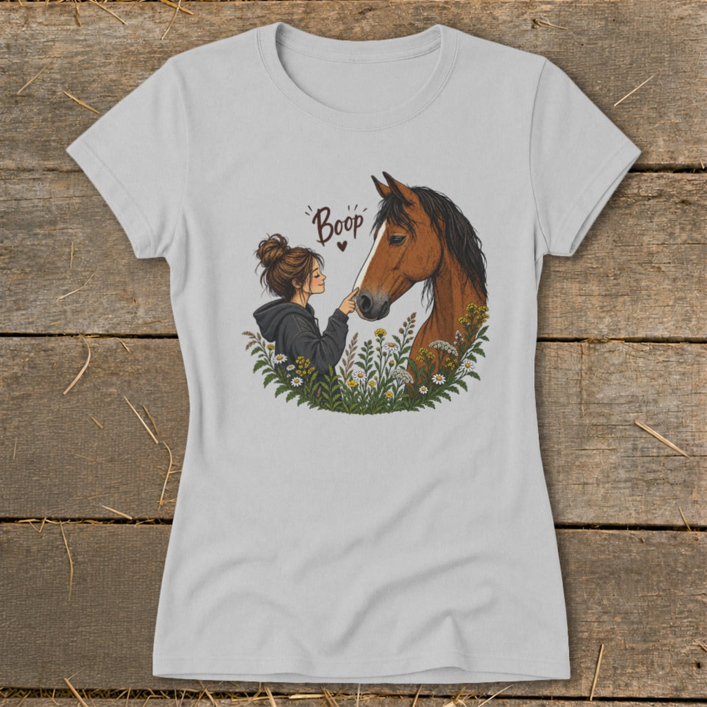 T-shirt graphic of a girl booping a horse's nose surrounded by flowers.