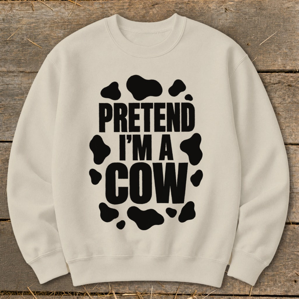Cream sweatshirt with black text "PRETEND I'M A COW" and cow spots.