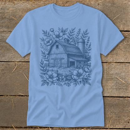 Light blue t-shirt with a sketch of a barn and silo surrounded by flowers.