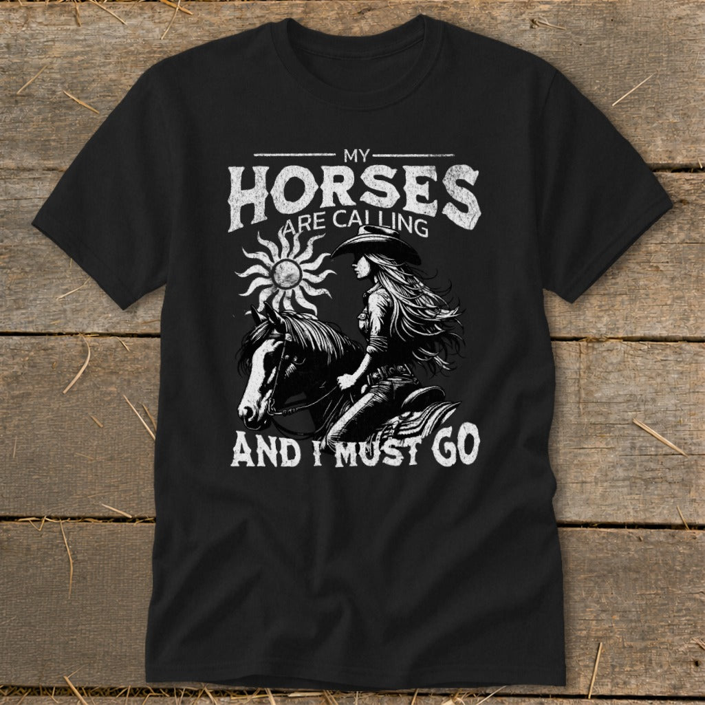 Black t-shirt with graphic: woman on horse, sun, and text "My Horses Are Calling And I Must Go".