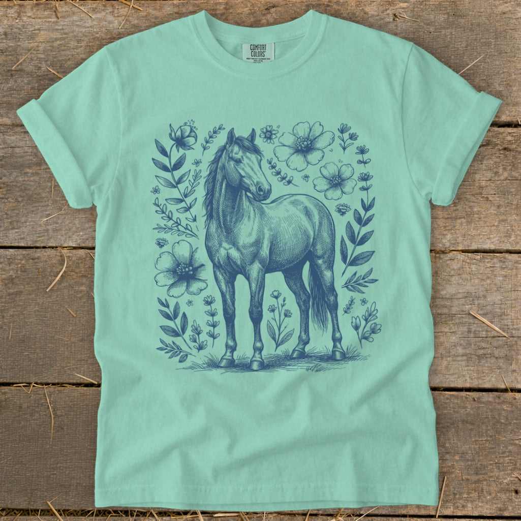 Teal t-shirt with a navy blue sketched horse surrounded by floral designs.