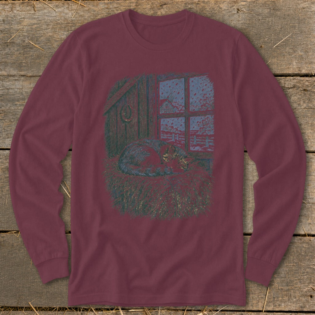 Long-sleeved shirt with a graphic of a sleeping cat in hay by a window.