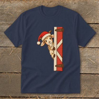 A goat wearing a Santa hat peeks from behind a red barn door.
