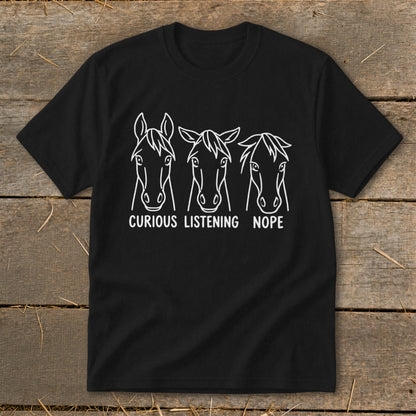 Black short-sleeve t-shirt featuring three white horse head line drawings with the text Curious, Listening, and Nope underneath.