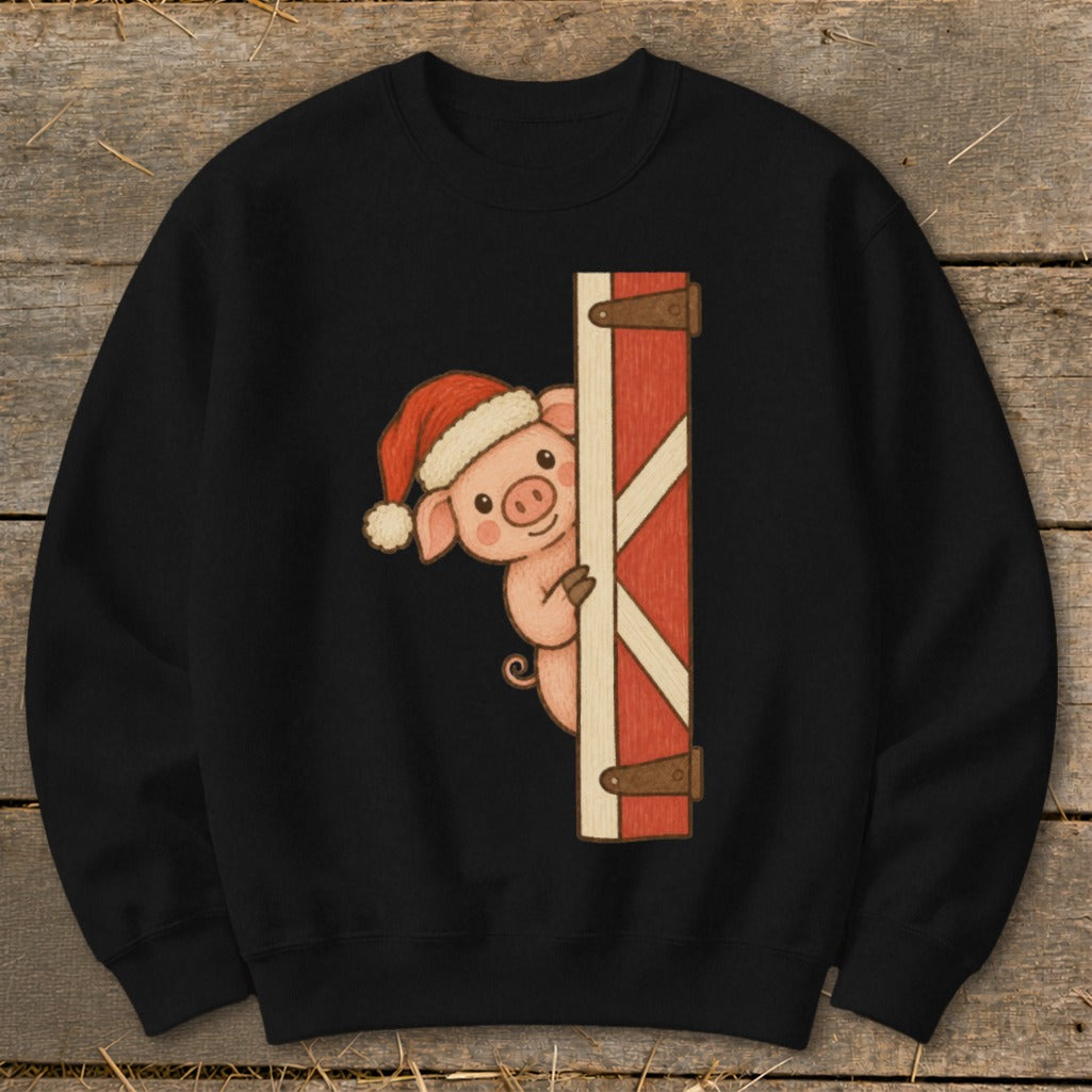 Black sweatshirt with a cartoon pig wearing a Santa hat peeking from behind a red barn door.