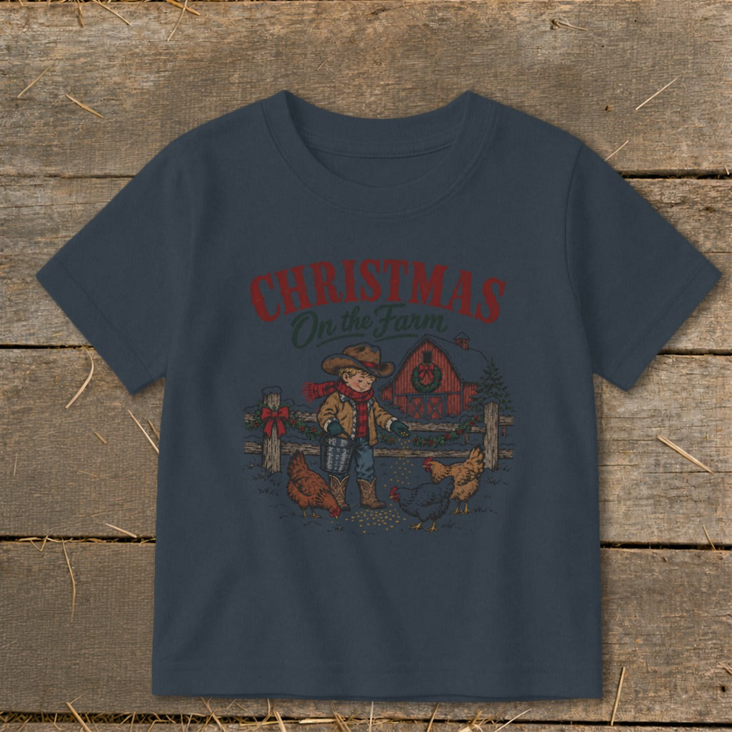 T-shirt graphic shows a boy feeding chickens with a red barn and "Christmas On the Farm" text.