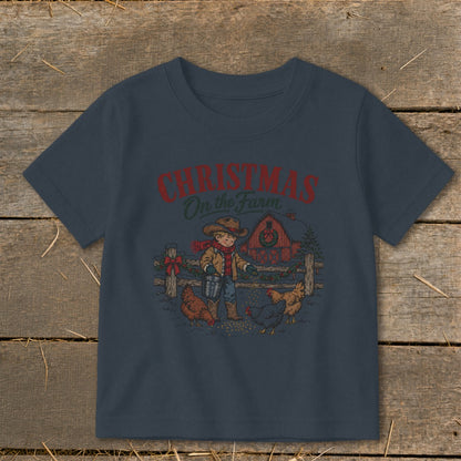 T-shirt graphic shows a boy feeding chickens with a red barn and "Christmas On the Farm" text.