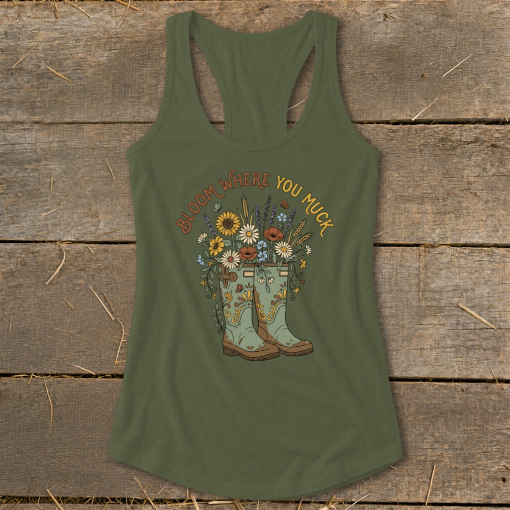 Green tank top with "Bloom Where You Muck" text and floral boots graphic.