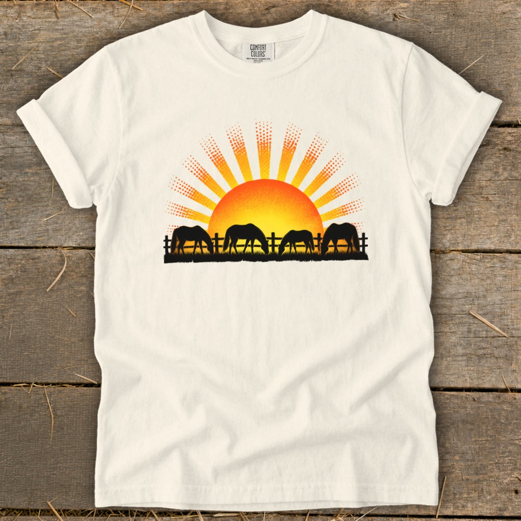 T-shirt with a graphic of horses grazing at sunrise.