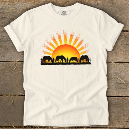 T-shirt with a graphic of horses grazing at sunrise.