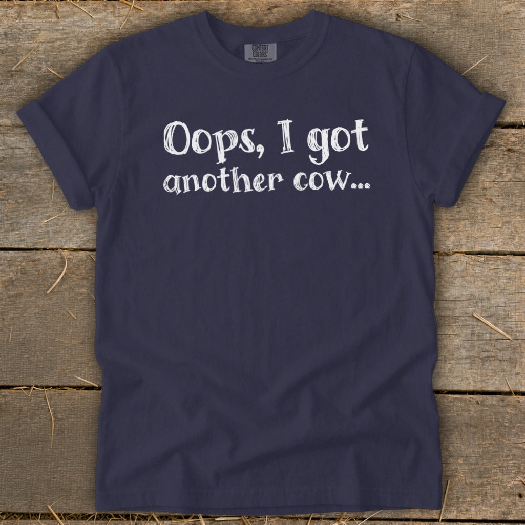 Navy t-shirt with white text reading "Oops, I got another cow...".