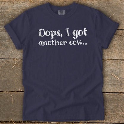 Navy t-shirt with white text reading "Oops, I got another cow...".