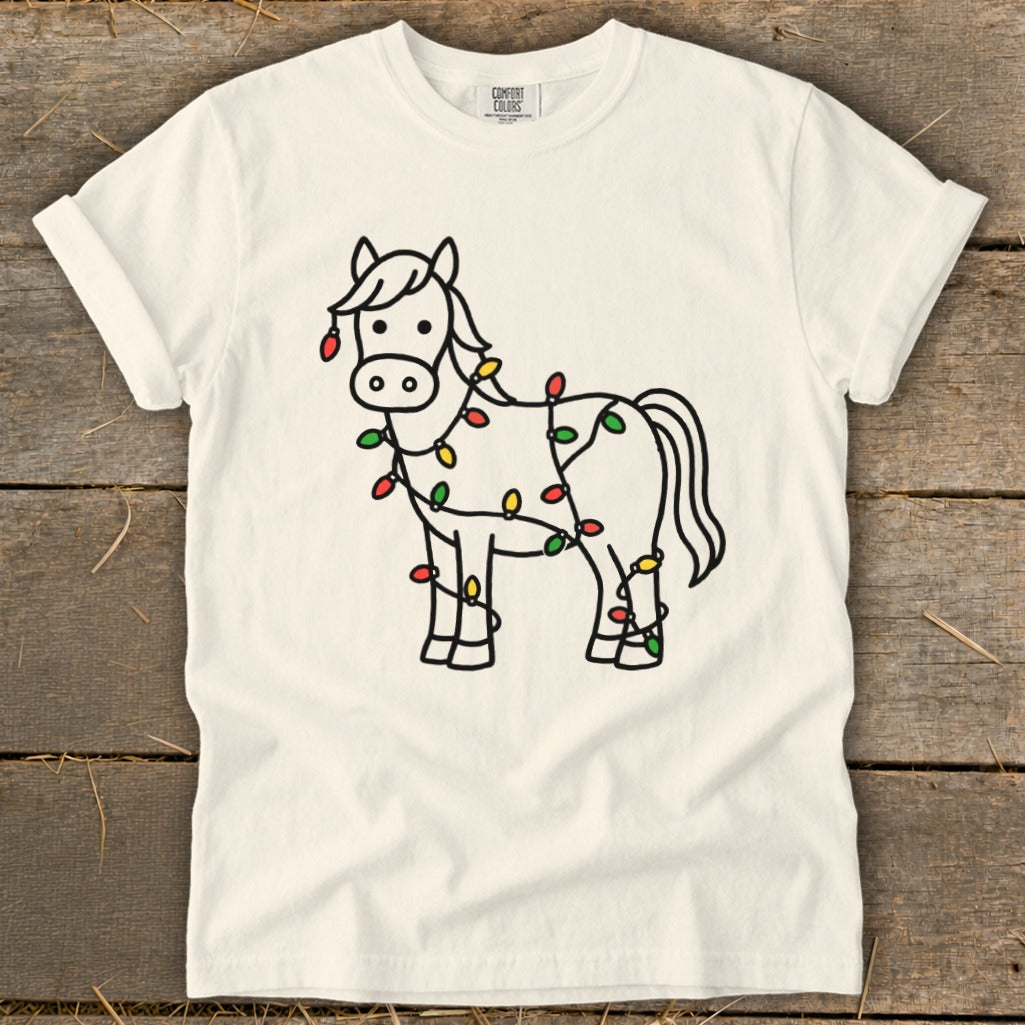 Line art of a horse wrapped in colorful Christmas lights on a cream t-shirt.