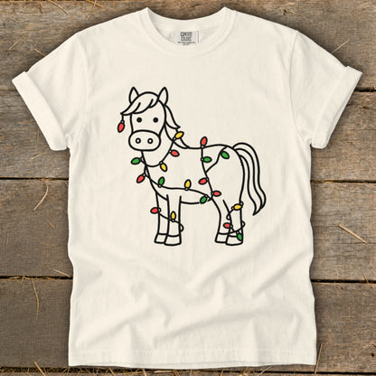 Line art of a horse wrapped in colorful Christmas lights on a cream t-shirt.