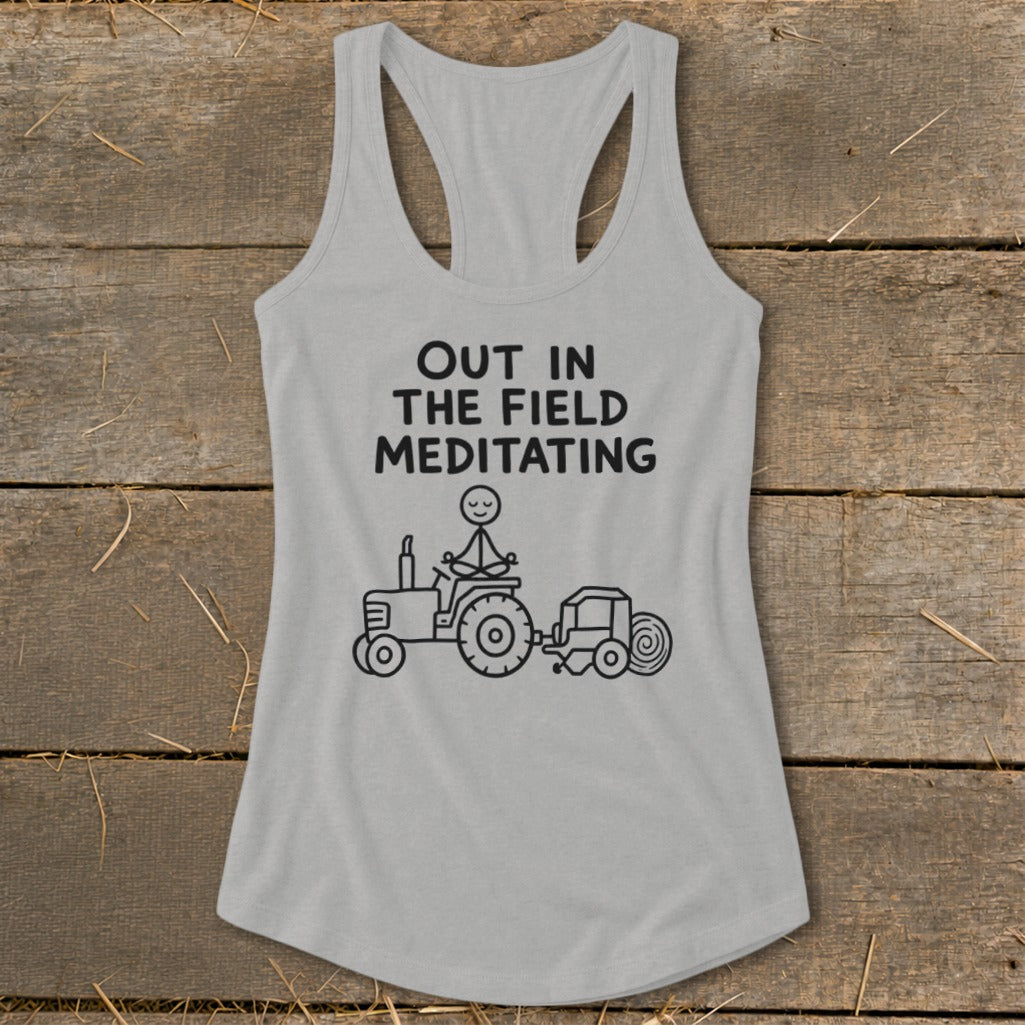 Gray tank top with text "OUT IN THE FIELD MEDITATING" and cartoon tractor.
