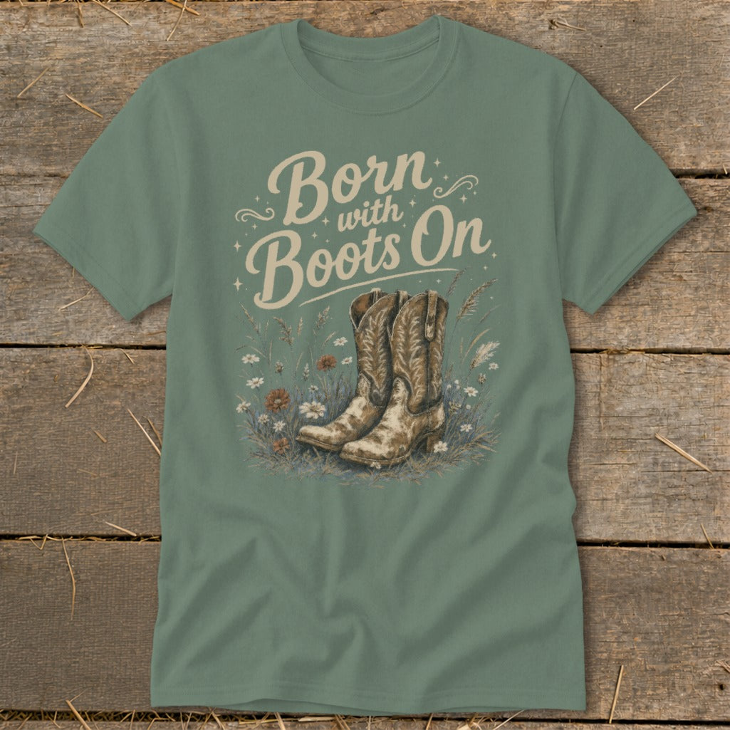 Green t-shirt with "Born with Boots On" text and cowboy boots in wildflowers.