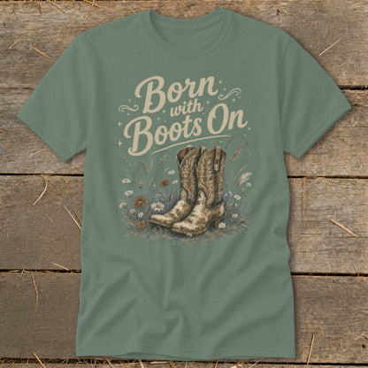 Green t-shirt with "Born with Boots On" text and cowboy boots in wildflowers.