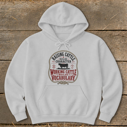 White hoodie with "Raising Cattle Builds Character" and "Working Cattle Builds Vocabulary" text.