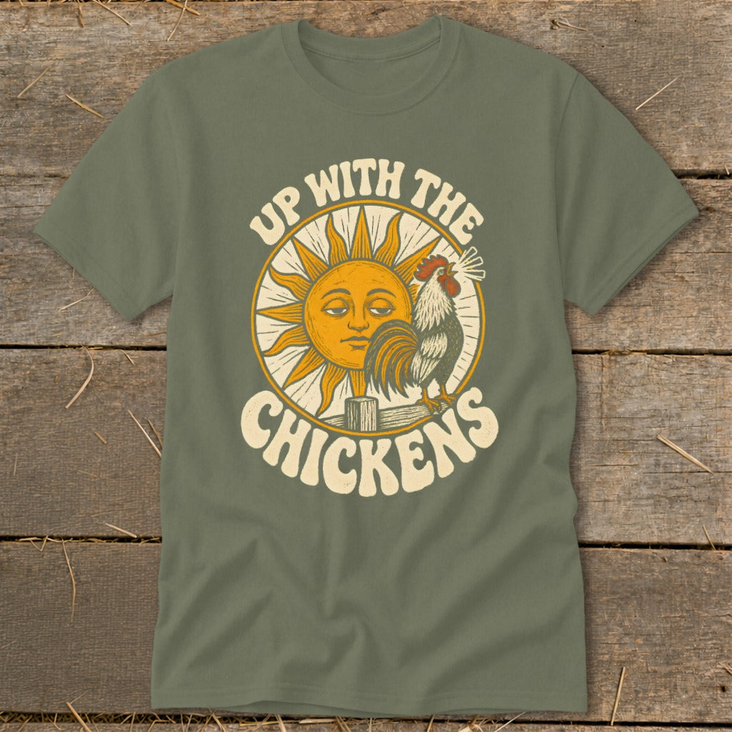 An olive green t-shirt featuring a retro graphic of a crowing rooster and sun with the text Up With The Chickens.