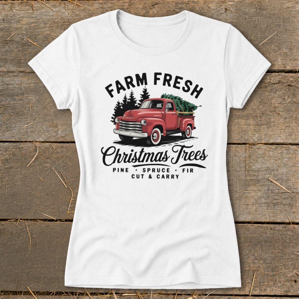 White t-shirt graphic with red pickup truck carrying Christmas trees, "Farm Fresh Christmas Trees" text.