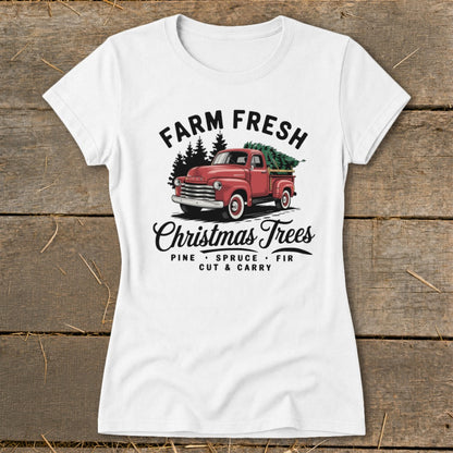 White t-shirt graphic with red pickup truck carrying Christmas trees, "Farm Fresh Christmas Trees" text.