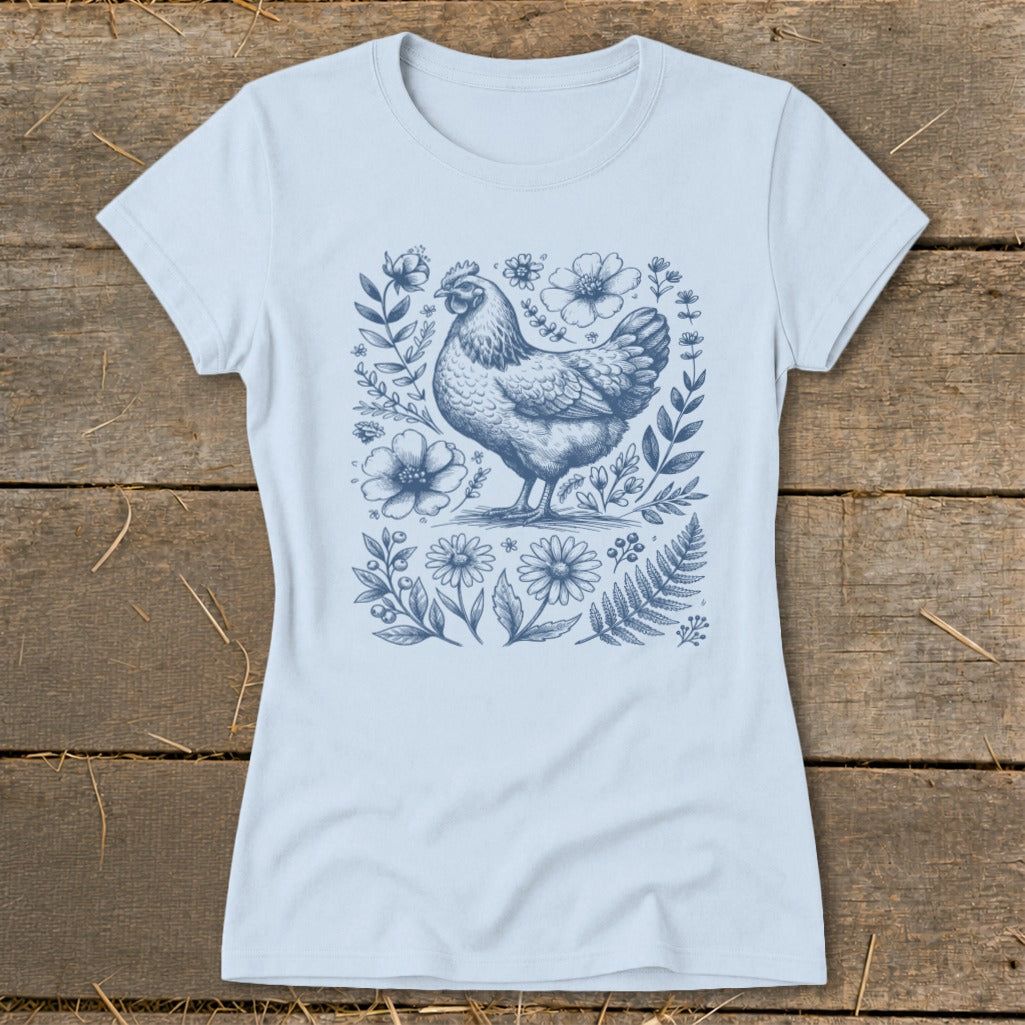 Light blue t-shirt with a blue ink drawing of a chicken surrounded by flowers and foliage.